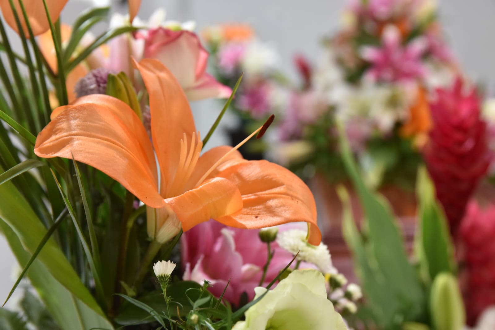 Detalle de un lirio anaranjado en un arreglo floral