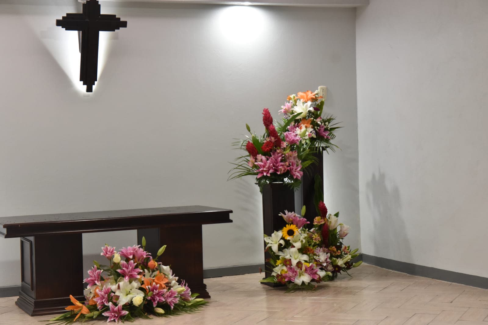 Mesa central de la sala de velación con arreglos de lirios